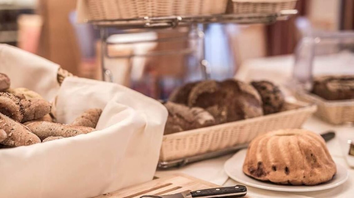 Frühstücksbuffet im NOVA Panoramarestaurant der Therme NOVA Köflach mit Brot, Gebäck und gedecktem Tisch im Innenbereich. | © Hotel & Therme NOVA