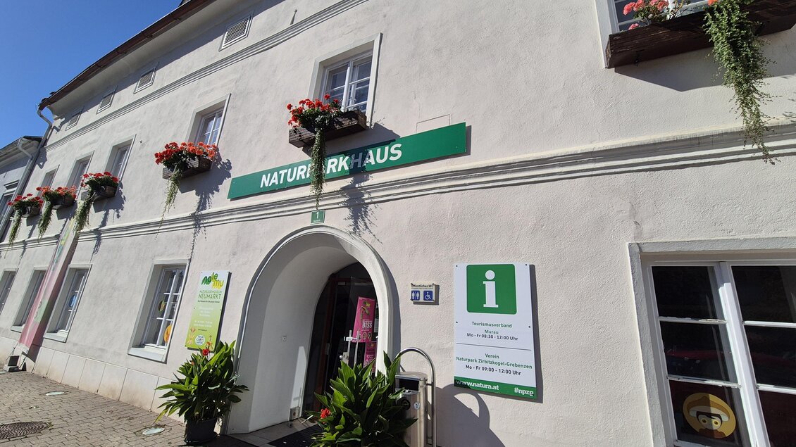 Ein älteres Gebäude mit einem Eingang, umgeben von Blumenkästen. Darauf steht das Schild "NATURPARKHAUS" und eine Informationsstelle ist sichtbar. | © TV Murau