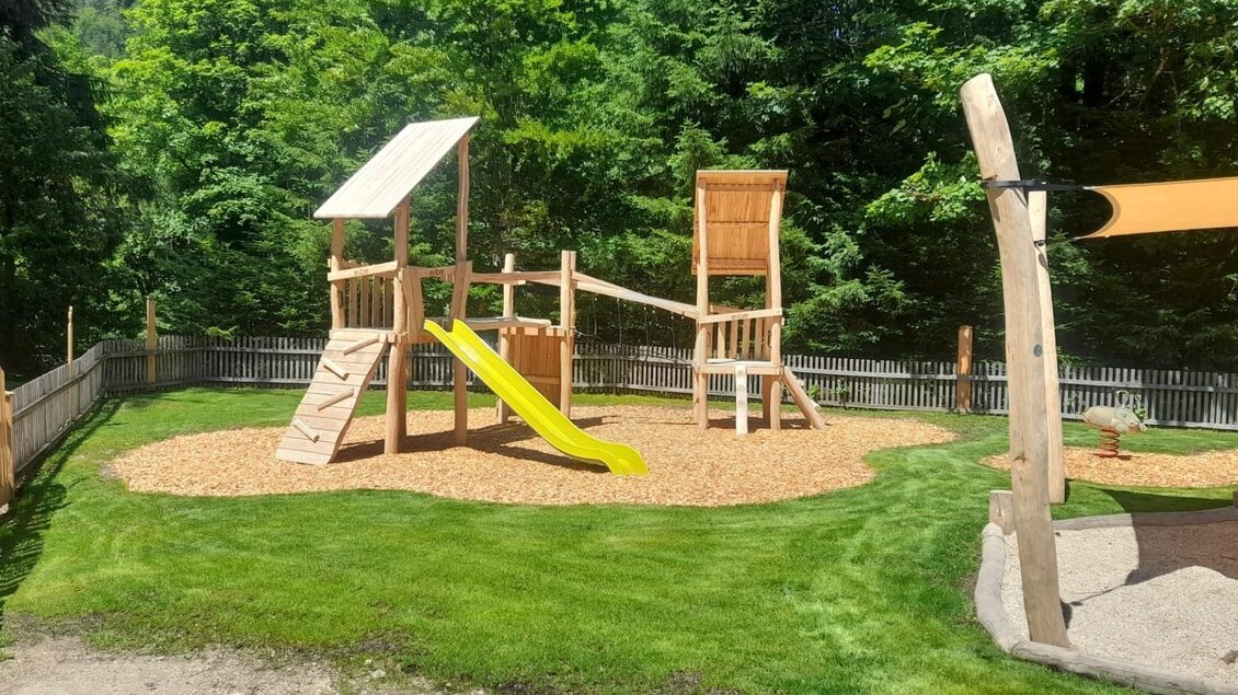 <p>Der Holzspielplatz mit einer Rutsche und einem Klettergerüst in der Natur um den Ödensee.</p> | © Isabell Schachner