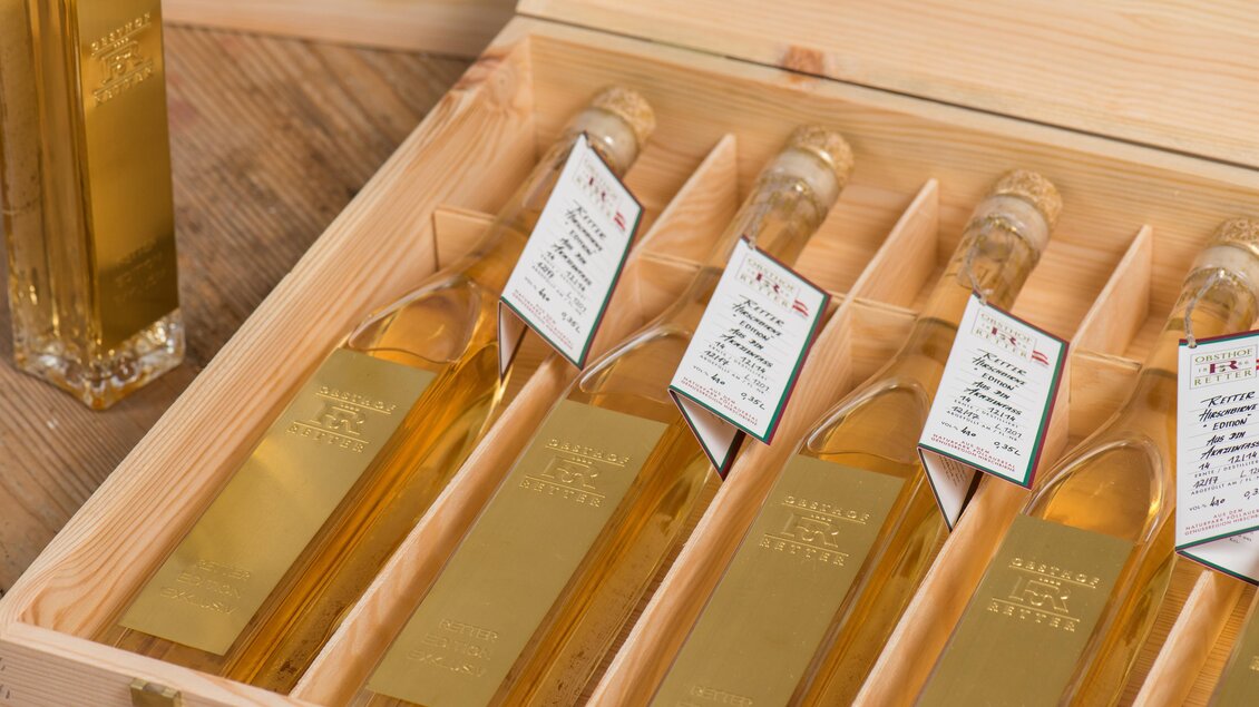 Eine elegante Holzkiste mit mehreren Flaschen goldfarbenem Öl. Jede Flasche hat ein Etikett mit Informationen. | © Helmut Schweighofer