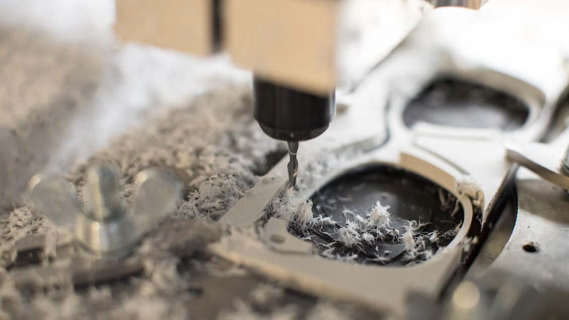 Eine CNC-Maschine bearbeitet ein Werkstück. Späne und Kunststoffreste sind sichtbar. | © Optik Ruck