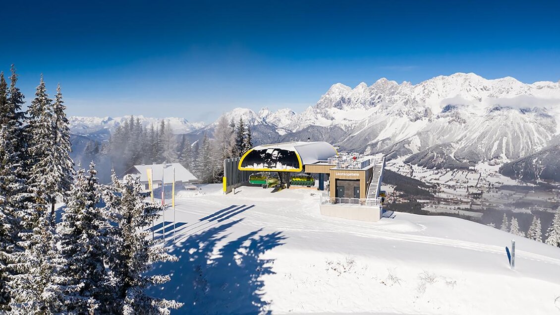 Eine schneebedeckte Berglandschaft mit einer modernen Gondelbahn. Im Hintergrund sind hohe Berge unter einem klaren blauen Himmel zu sehen. | © Johannes Absenger