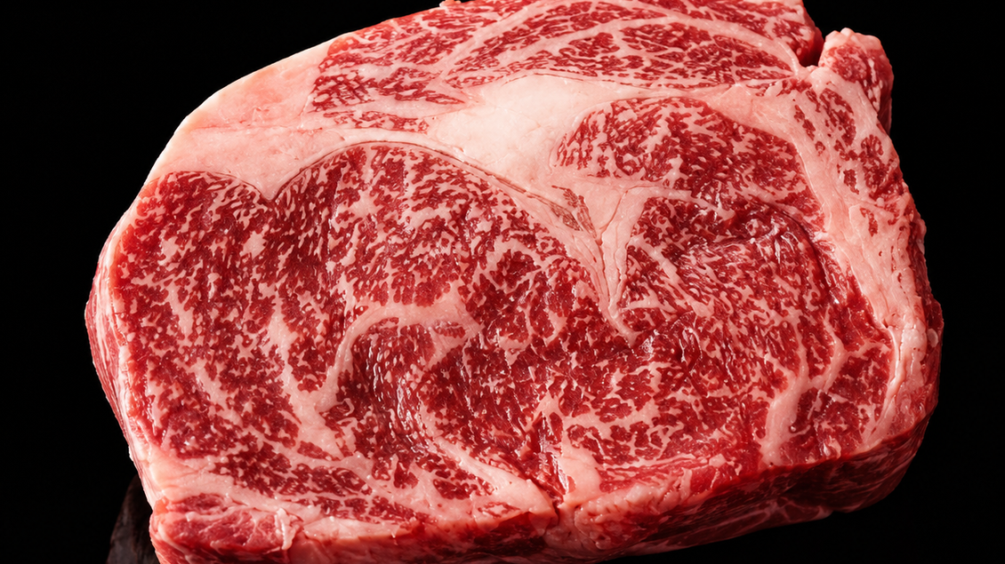 Ein Stück hochwertiges Fleisch mit feiner Marmorierung. Es liegt auf einem schwarzen Hintergrund und wirkt besonders appetitlich. | © Familie Lanz