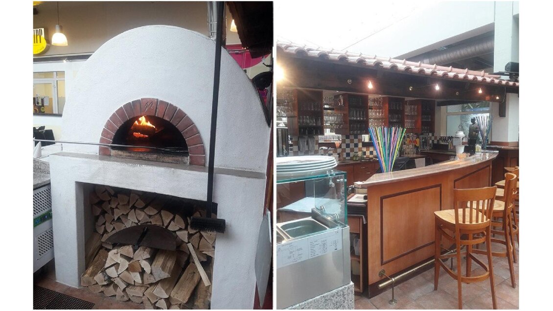 Ein traditioneller Pizzaofen mit brennendem Holz, links im Bild. Rechts ein einladender Barbereich mit Holzstühlen und einer gut gefüllten Theke. | © Pizzeria Ristorante La Piazza