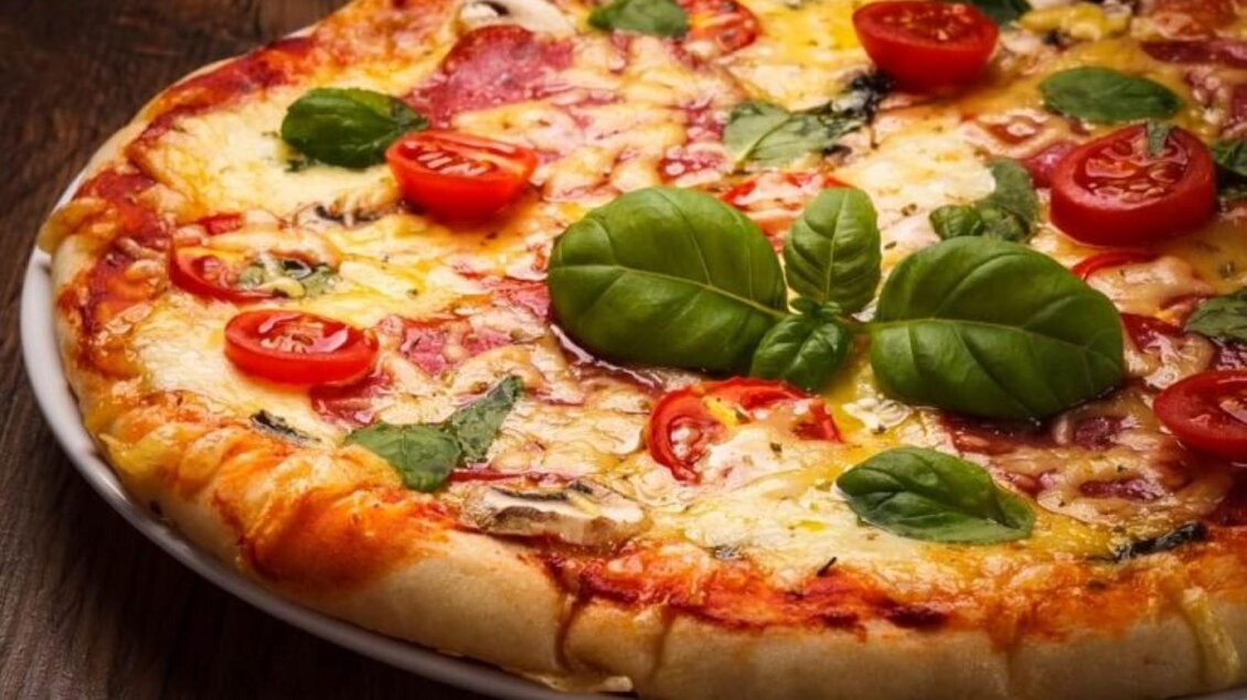 Eine köstliche Pizza mit Tomaten, Basilikum und Käse. Der knusprige Rand verleiht ihr zusätzlichen Geschmack. | © Pizzeria DAVID