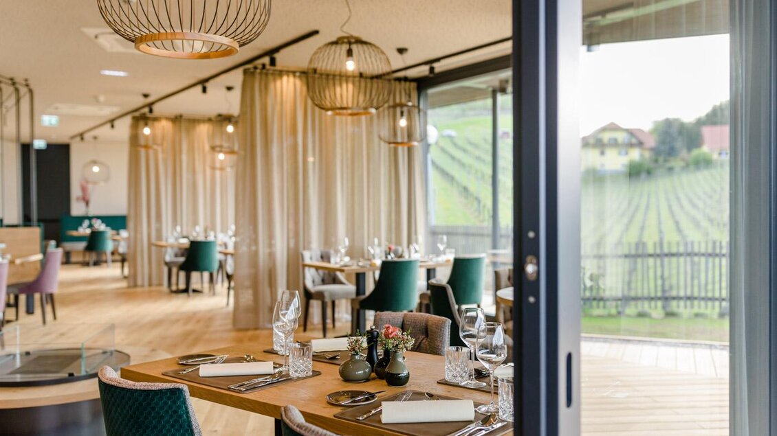 Ein modernes Restaurant mit eleganten Möbeln und großen Fenstern. Der Blick auf Weinberge und eine entspannte Atmosphäre laden zum Verweilen ein. | © Karin Bergmann
