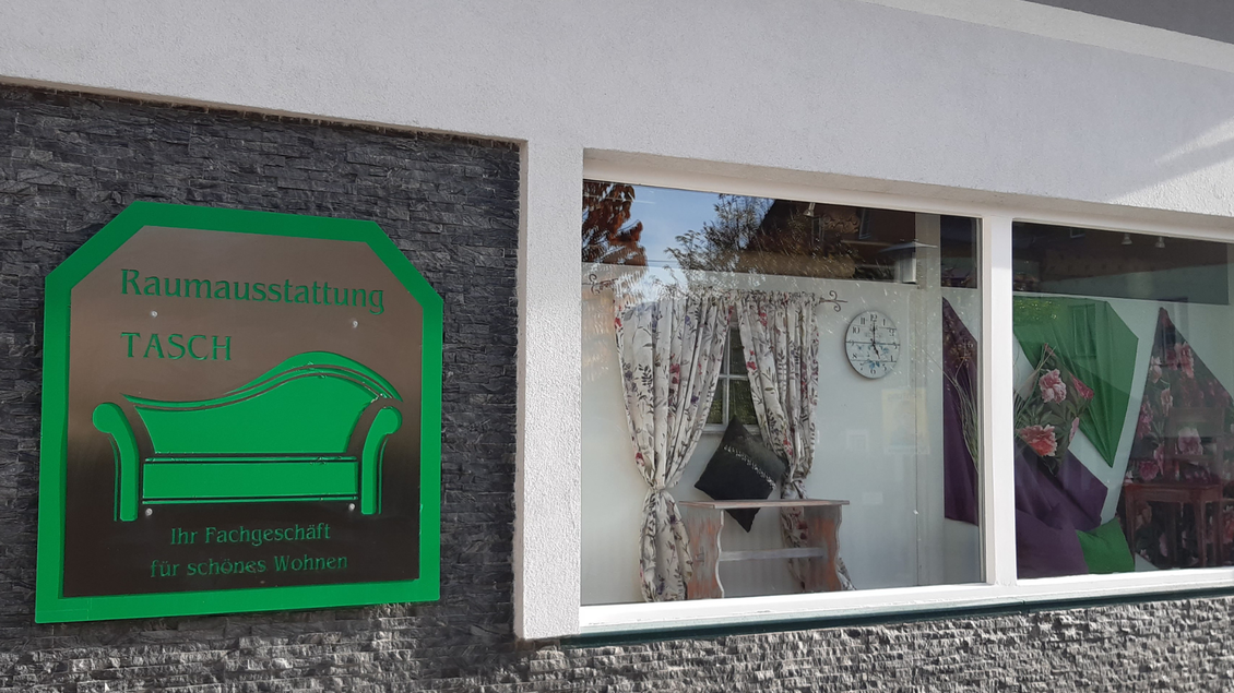 Ein Geschäft für Raumausstattung mit einem Schild und klaren Fenstern. Im Schaufenster sind Vorhänge und Möbel zu sehen. | © TVB Ausseerland Salzkammergut_Daniela Casari