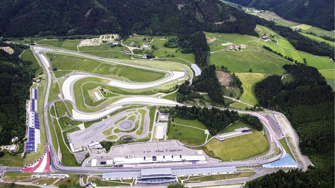 Ein Luftbild einer Rennstrecke umgeben von grünen Feldern und Bergen. Die Strecke zeigt verschiedene Kurven und Einrichtungen für Motorsportveranstaltungen. | © Erlebnisregion Murtal