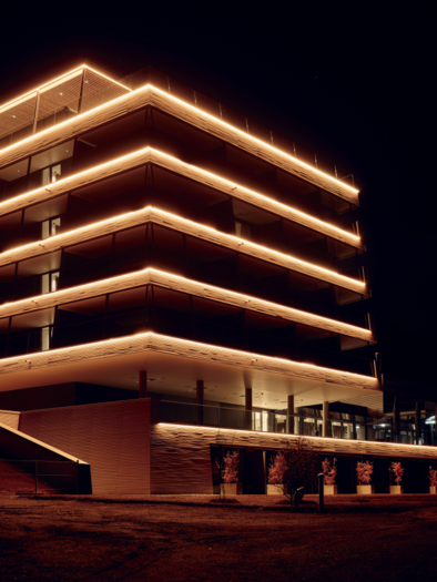Ein modernes Gebäude mit leuchtenden Lichträndern bei Nacht. Die Fassade ist elegant und einladend gestaltet. | © Tauroa GmbH