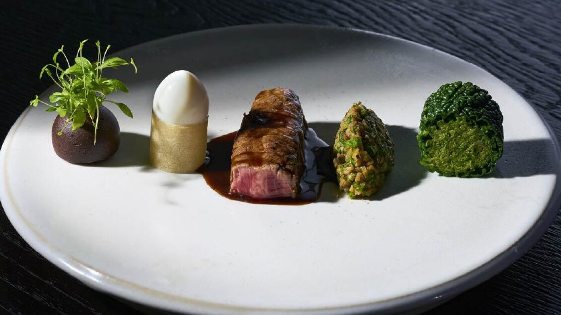 Modern angerichtetes Hauptgericht mit Fleisch, Gemüse und Dekoration im Restaurant Artis Graz. | © Sebastian Knapp