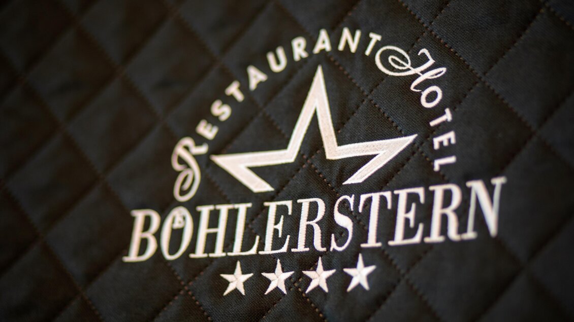 Ein elegant gestaltetes Logo des Restaurants und Hotels Bohlerstern. Es zeigt einen fünfzackigen Stern auf einem schwarzen Hintergrund.