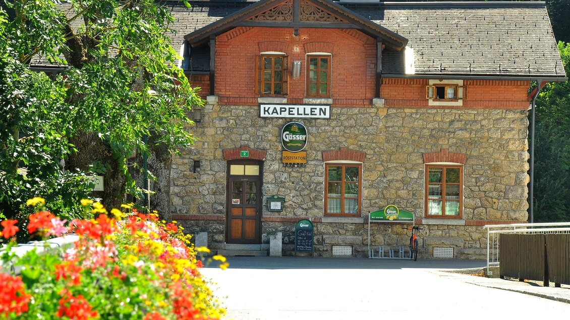Ein charmantes Gebäude mit Steinmauern und einem roten Dach. Vor dem Eingang blühen bunte Blumen. | © Röststation