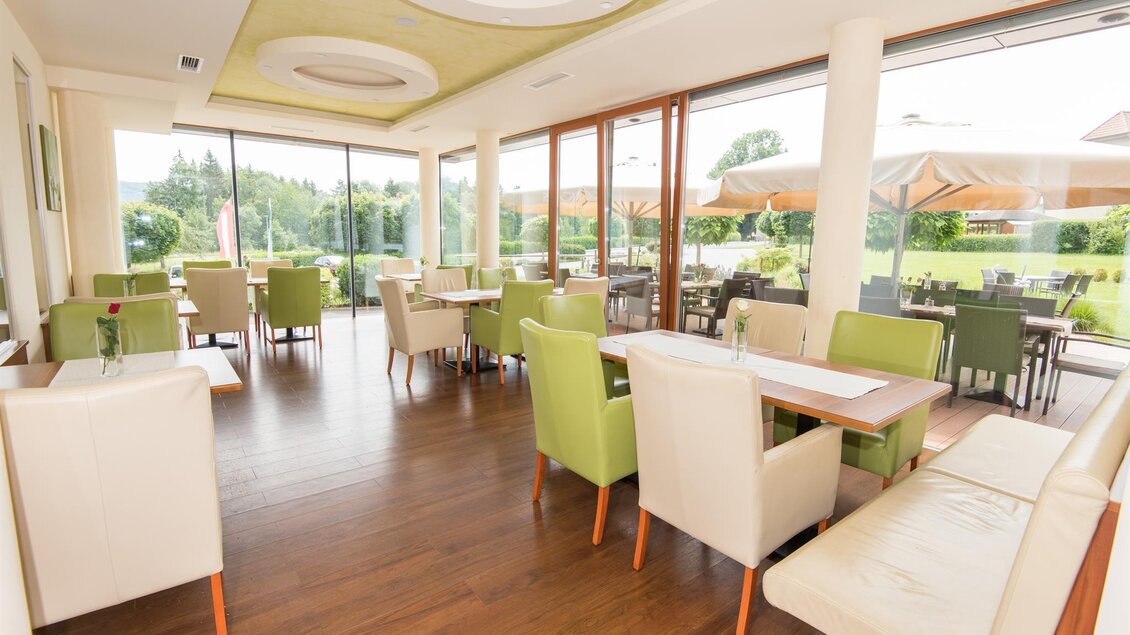 Ein helles und einladendes Restaurant mit modernen Möbeln. Große Fenster bieten einen Blick auf die Außenanlage. | © Hotel-Restaurant Gruber