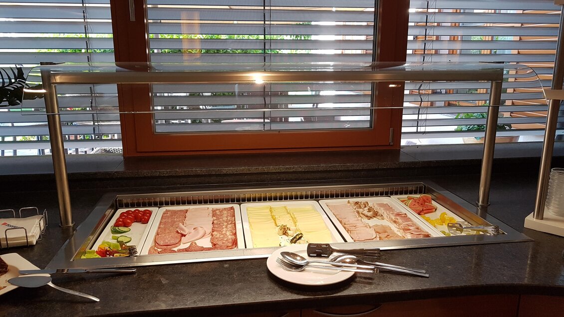Ein Buffet mit verschiedenen Wurst- und Käsesorten sowie frischem Gemüse. Die Auslage ist unter einer transparenten Abdeckung platziert. | © Tourismusverband Oststeiermark