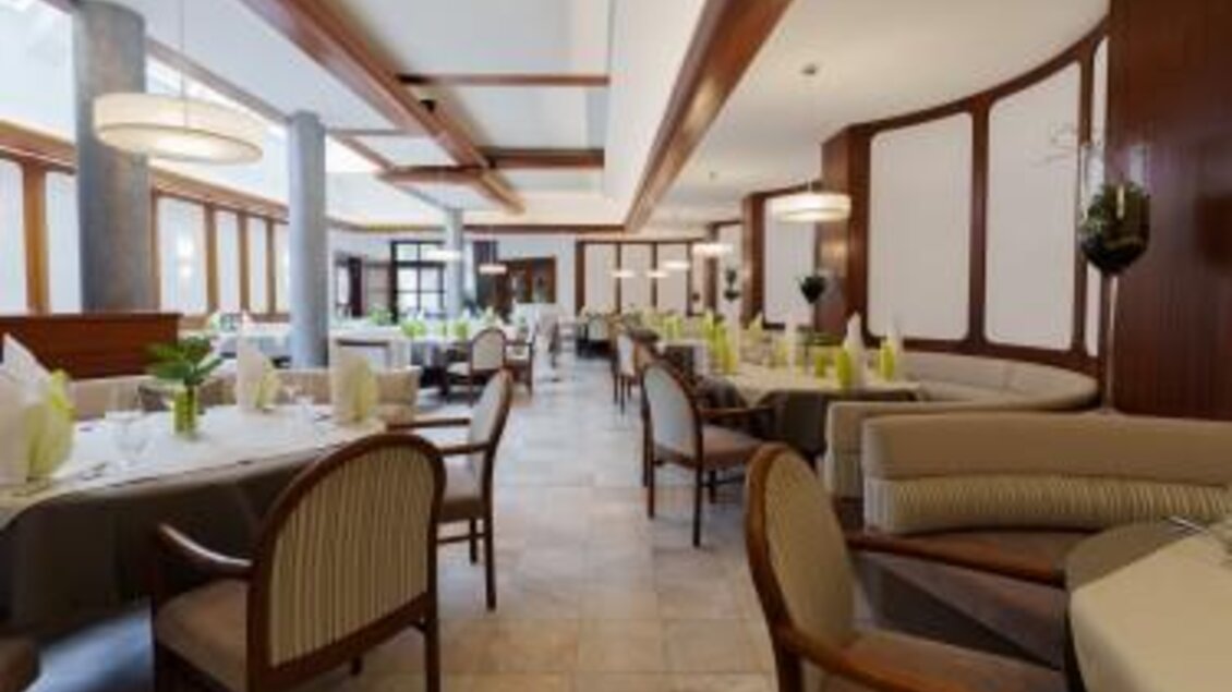 Ein elegantes Restaurant mit stilvoller Einrichtung. Die Tische sind fein gedeckt und die Atmosphäre ist einladend.