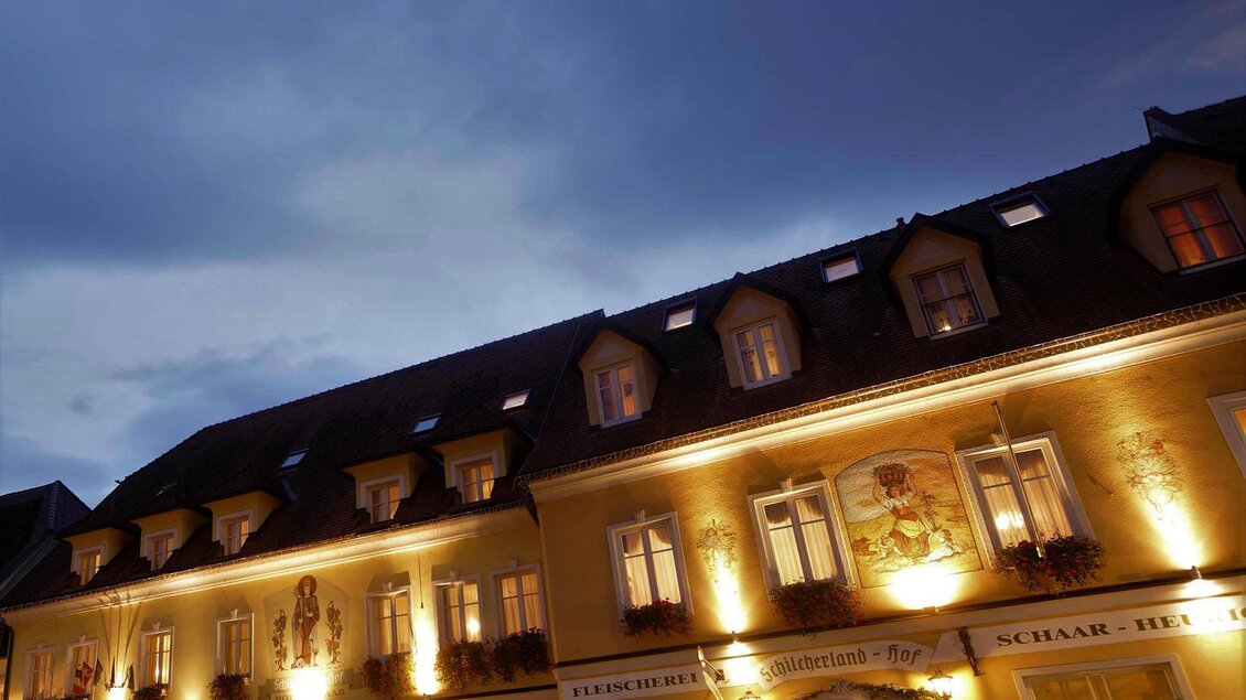 Ein stilvolles Gebäude beleuchtet bei Dämmerung. Die Architektur ist traditionell und einladend. | © Schilcherland Hof