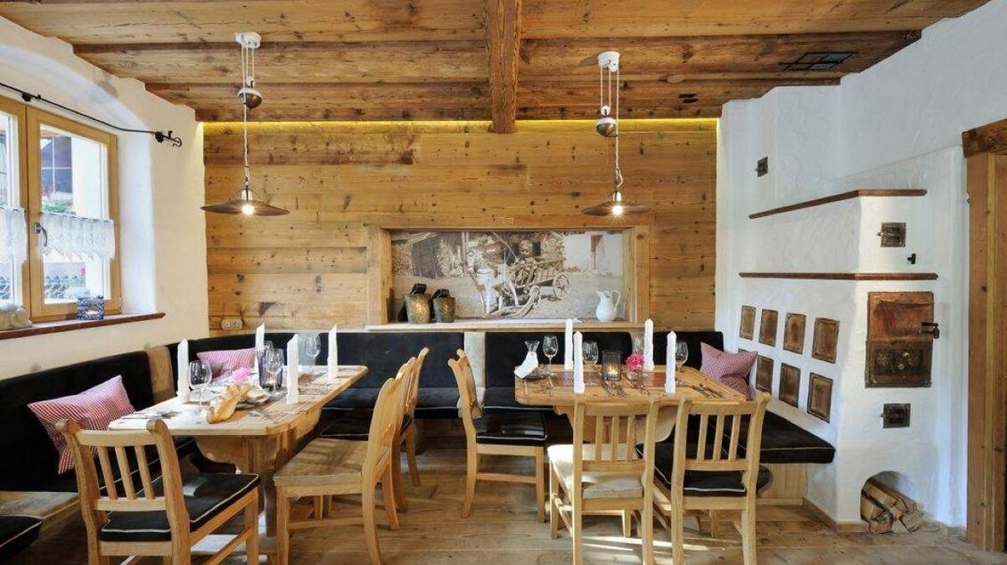 Rustikale Gaststube mit viel Holz, liebevoll gedeckten Tischen und warmem, einladendem Ambiente. | © Hotel Herrschaftstaverne