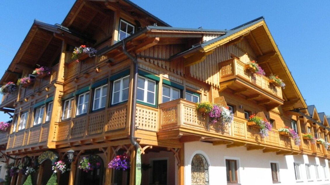 Das Kanzler Wander- und Wellnesshotel, ein traditionelles Ausseer Haus aus Holz mit vielen Fenstern und bunten Balkonblumen. | © Landhotel-Restaurant Kanzler