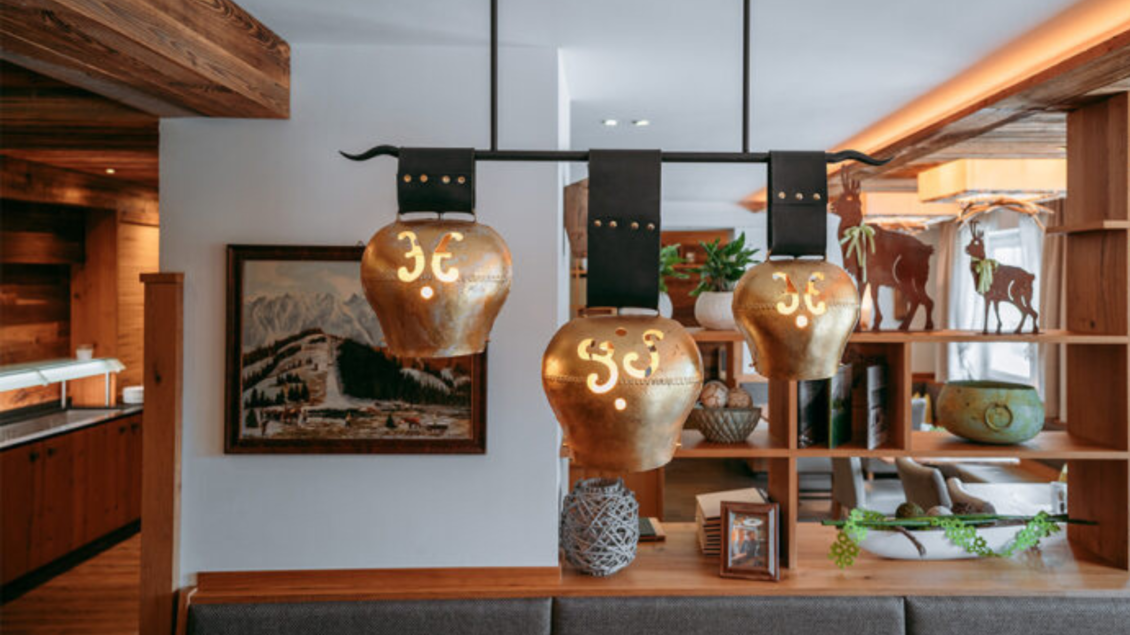 Das stilvolle Restaurant im Kanzler Wander- und Wellnesshotel mit goldenen Kuhglocken als Dekoration und rustikalen Holzelementen. | © Gasthaus Kanzler