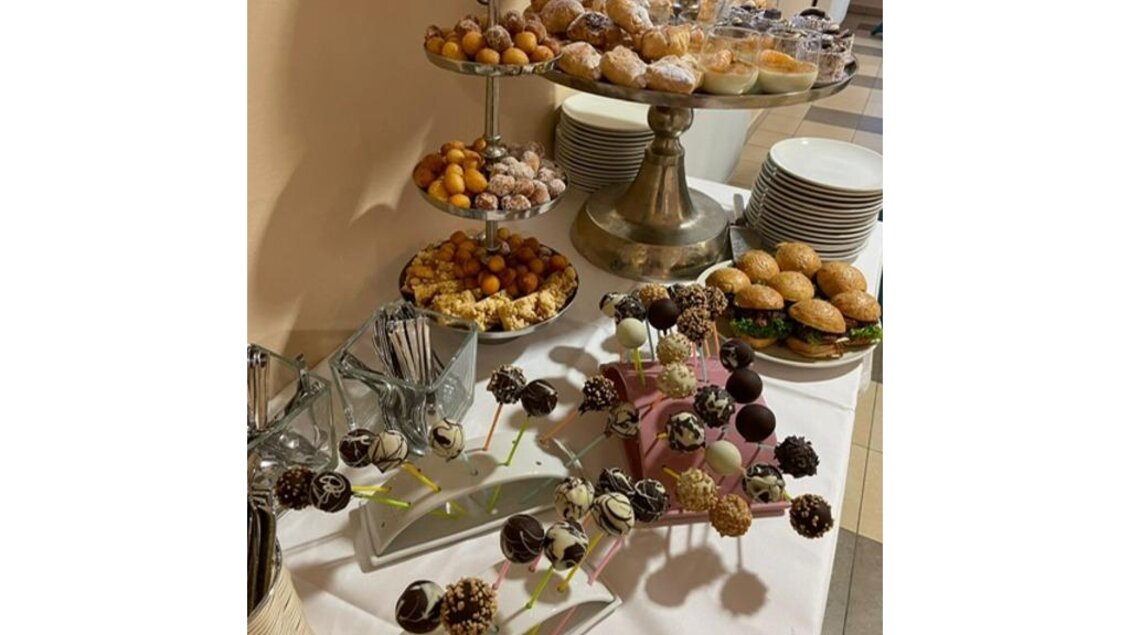 Ein reichhaltiges Buffet mit verschiedenen süßen Snacks, darunter Kuchen, Gebäck und Schokoladenleckereien. Es gibt auch dekorierte Essensstiele und eine elegante Präsentation. | © JUFA Hotel Leibnitz