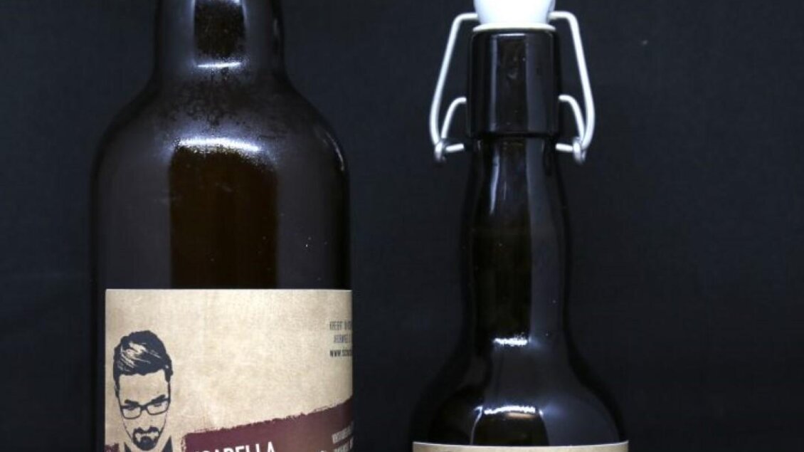 Zwei Flaschen Bier mit etikettiertem Design. Die größere Flasche ist dunkelbraun und die kleinere Flasche hat ebenfalls ein ähnliches Etikett. | © Richards Bieratelier