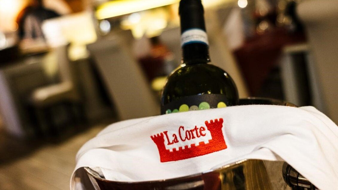 Weinflasche im Kühler im Restaurant La Corte in Voitsberg mit Blick auf den Innenbereich. | © La Corte - Urbano