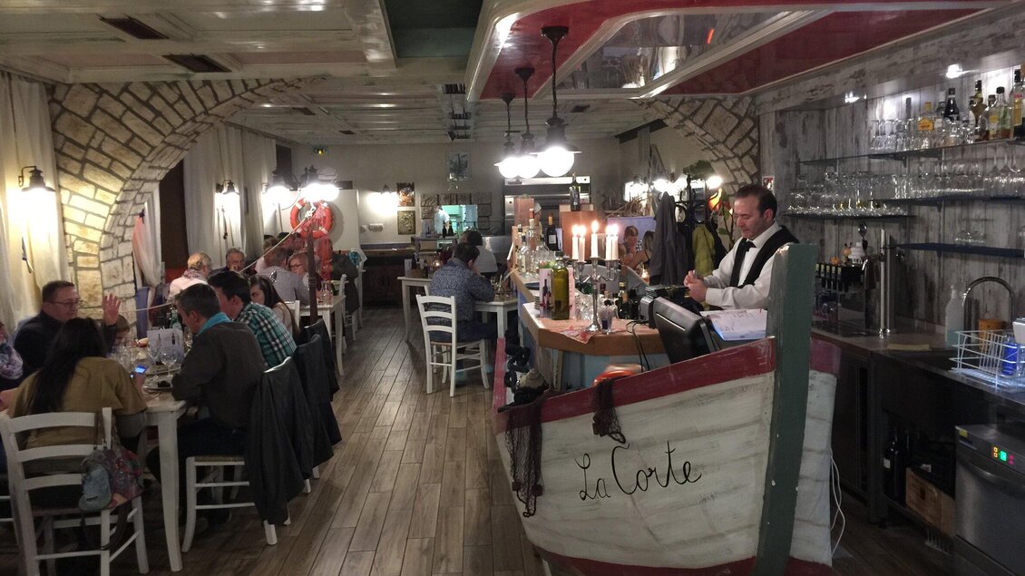 Gäste und Barbereich im Ristorante La Corte in Voitsberg mit rustikalem Innenraum. | © La Corte - Urbano