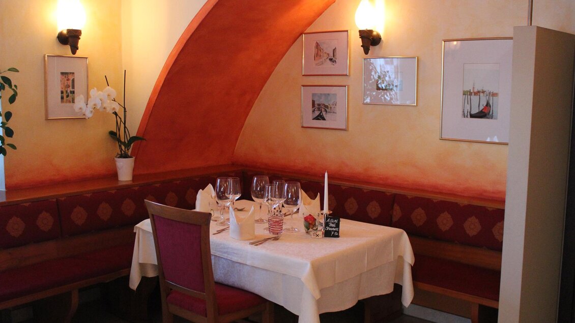 Ein gemütliches Restaurant mit einem schön gedeckten Tisch. Die Wände sind in warmen Farben gestrichen und es gibt dekorative Bilder. | © Da Gino