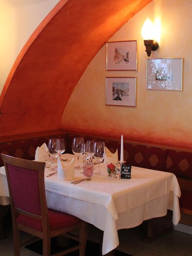 Ein gemütliches Restaurant mit einem schön gedeckten Tisch. Die Wände sind in warmen Farben gestrichen und es gibt dekorative Bilder. | © Da Gino