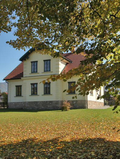 Ein charmantes Haus umgeben von buntem Herbstlaub. Der klare Himmel und die grüne Wiese verleihen der Szene eine einladende Atmosphäre. | © Jakob Hiller