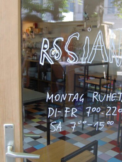 Ein Restaurant mit dem Namen "RSSIAN" ist zu sehen. Die Öffnungszeiten sind auf dem Fenster aufgeschrieben. | © Rossian