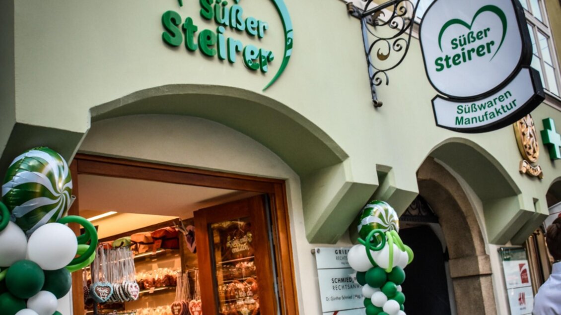 Eingang der Süßwarenmanufaktur „Süßer Steirer“ in Graz mit Ballondeko und Blick auf den Verkaufsraum. | © Süßer Steirer