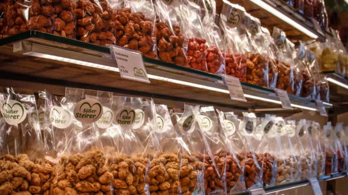 Regale mit abgepackten Süßwaren und gebrannten Nüssen der Marke „Süßer Steirer“ in Graz. | © Süßer Steirer