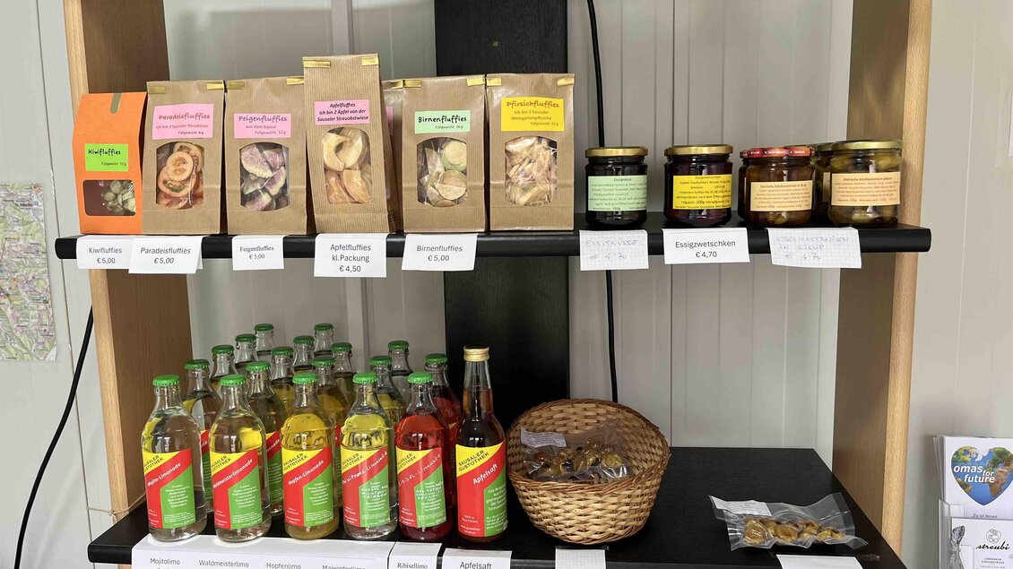 Ein Regal mit verschiedenen Lebensmitteln, darunter Tees, Marmeladen und Limonade. Die Produkte sind in hübschen Verpackungen und Gläsern angeordnet. | © Sausaler Gustothek | Dr. Ulrike Schauer