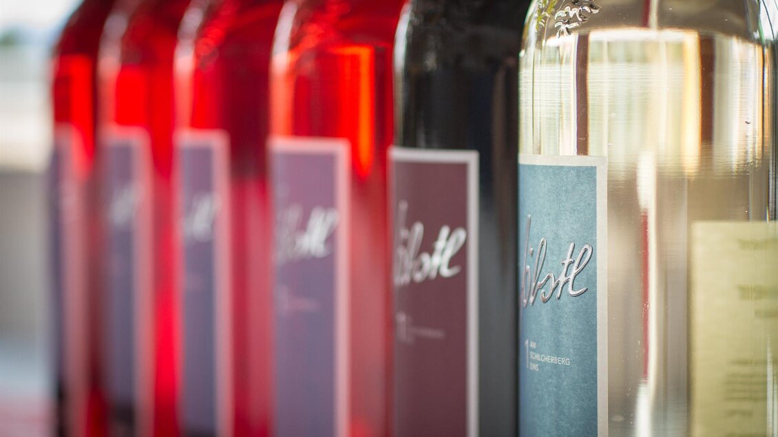 Eine Reihe von Weinetiketten in verschiedenen Farben, darunter Rot, Weiß und Rosé. Die Flaschen sind elegant angeordnet und strahlen ein modernes Design aus. | © Schilcherei Jöbstl