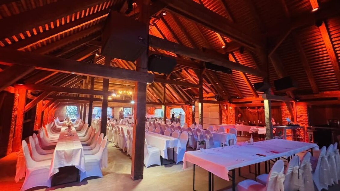 Ein stilvolles Restaurant mit Holzdecken und roter Beleuchtung. Die Tische sind elegant gedeckt und laden zu einem feierlichen Anlass ein. | © Hannes Kaufmann