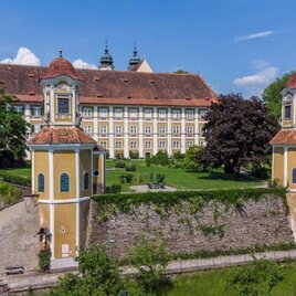 A picturesque landscape with a historic building and gentle hills in the background. The surroundings are green and inviting for exploration. | © Forstverwaltung Schloss Stainz