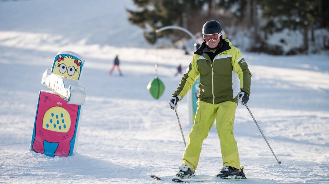 <p>Ein Skigebiet mit weißem Schnee und einer klaren blauen Himmel. Ein Skifahrer steht im Vordergrund auf der Piste.</p> | © Klaus Ranger