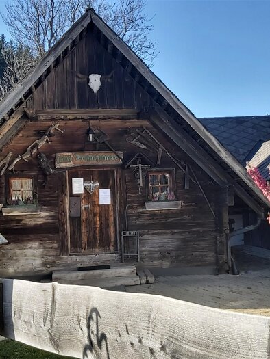 Ein charmantes, traditionelles Holzhaus mit einem spitzen Dach. Vor dem Gebäude stehen schöne Pflanzen und ein Holzzaun. | © Oststeiermark Tourismus