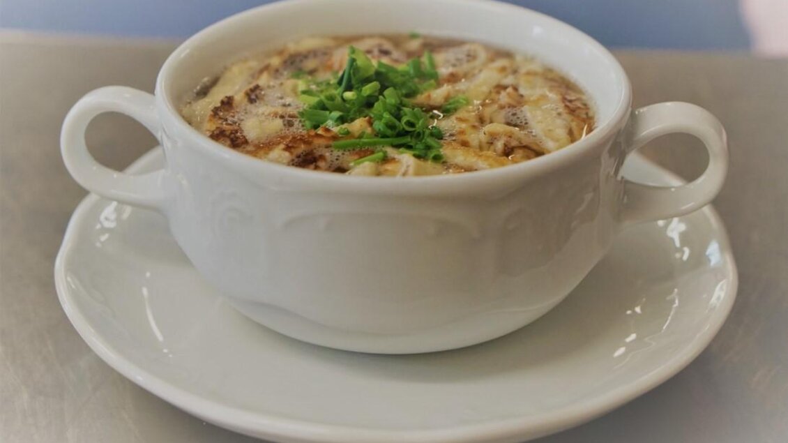Eine schmackhafte Suppe in einem weißen Becher mit zwei Griffen. Oben garniett mit frischen Kräutern. | © Seerestaurant Gruber