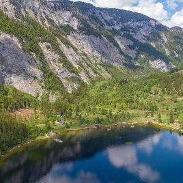<p><p>Ein ruhiger See umgeben von hohen Bergen und grünem Wald. Der Himmel ist klar mit einigen Wolken.</p></p> | © Drohnenfotos.at-Andreas Tischler