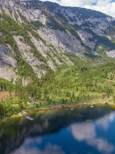 <p><p>Ein ruhiger See umgeben von hohen Bergen und grünem Wald. Der Himmel ist klar mit einigen Wolken.</p></p> | © Drohnenfotos.at-Andreas Tischler