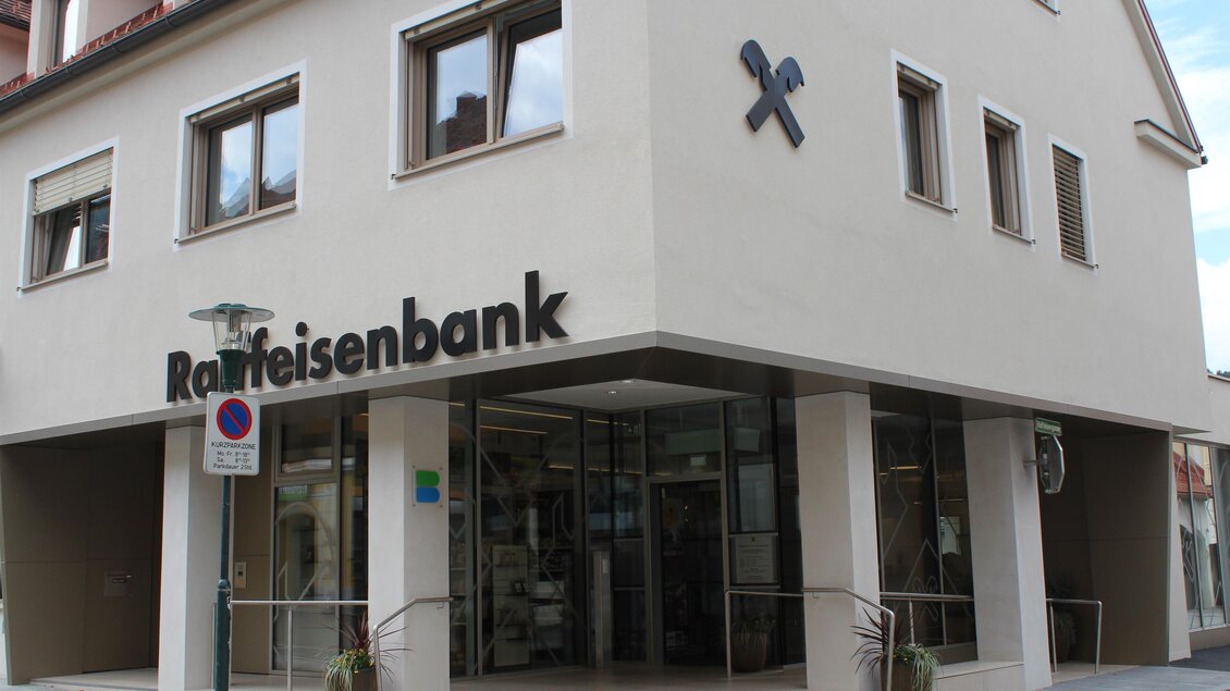 Die Raiffeisenbank ist ein modernes Gebäude mit großen Fenstern. Es befindet sich an einer Straßenecke und hat eine einladende Fassade. | © Alexandra Wippel