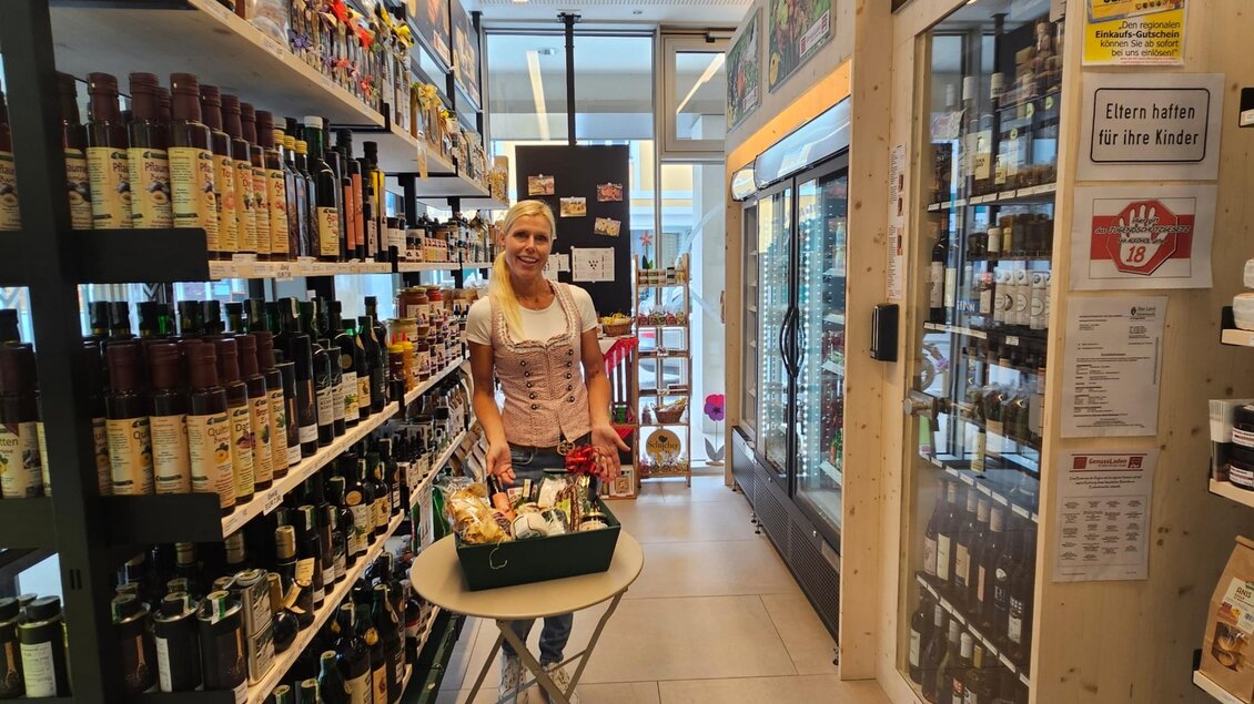 Ein gut sortierter Lebensmittelladen mit Regalen voller Flaschen. Eine Verkäuferin steht an einem Tisch mit Waren im Vordergrund. | © Verein Schilcherlandspezialitäten