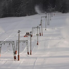 A snowy winter landscape with several ski lifts. The lifts are visible in the distance and surrounded by a lot of snow. | © Zlaim Lift