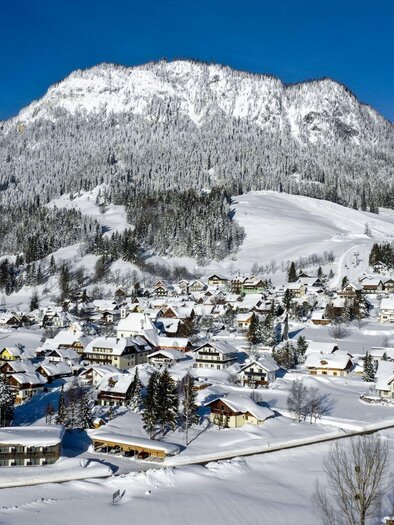 A snowy landscape with mountains and a small village. The houses are colorful and the surroundings are quiet and picturesque. | © TVB Ausseerland Salzkammergut/Tom Lamm