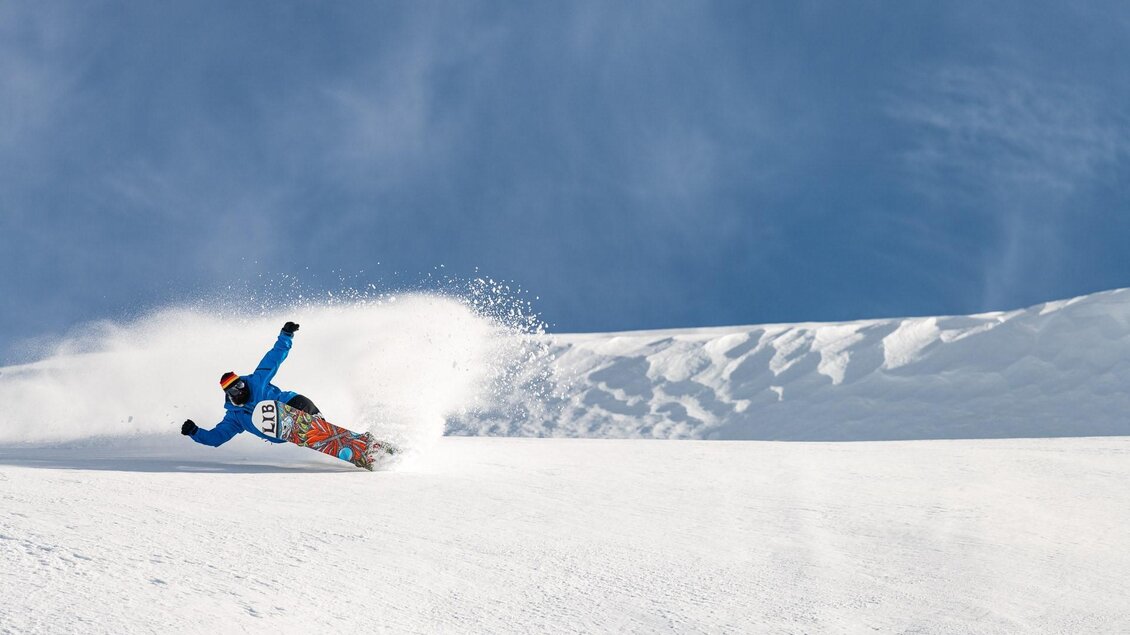 Ein Snowboarder fährt durch frischen Pulverschnee. Der Himmel ist klar und blau. | © Lib Tech