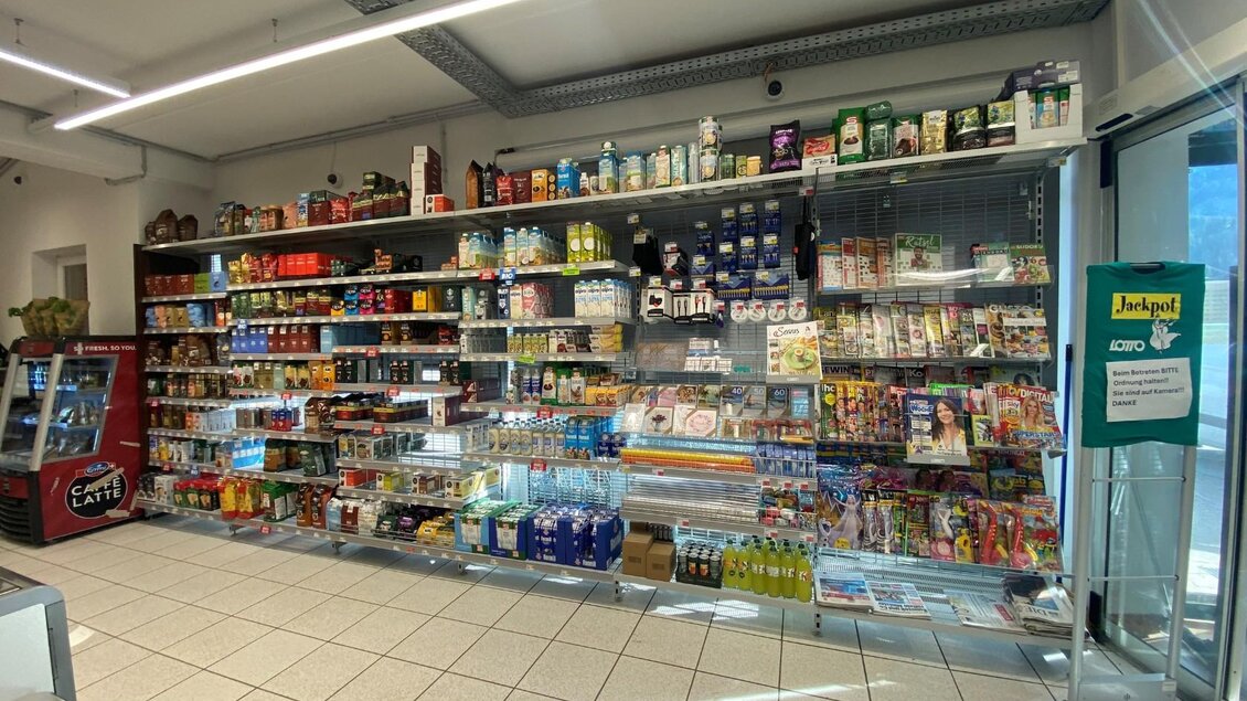 Ein Regal voller verschiedener Lebensmittel und Getränke in einem Geschäft. Die Produkte sind ordentlich angeordnet und gut sichtbar. | © Bettina Scheck