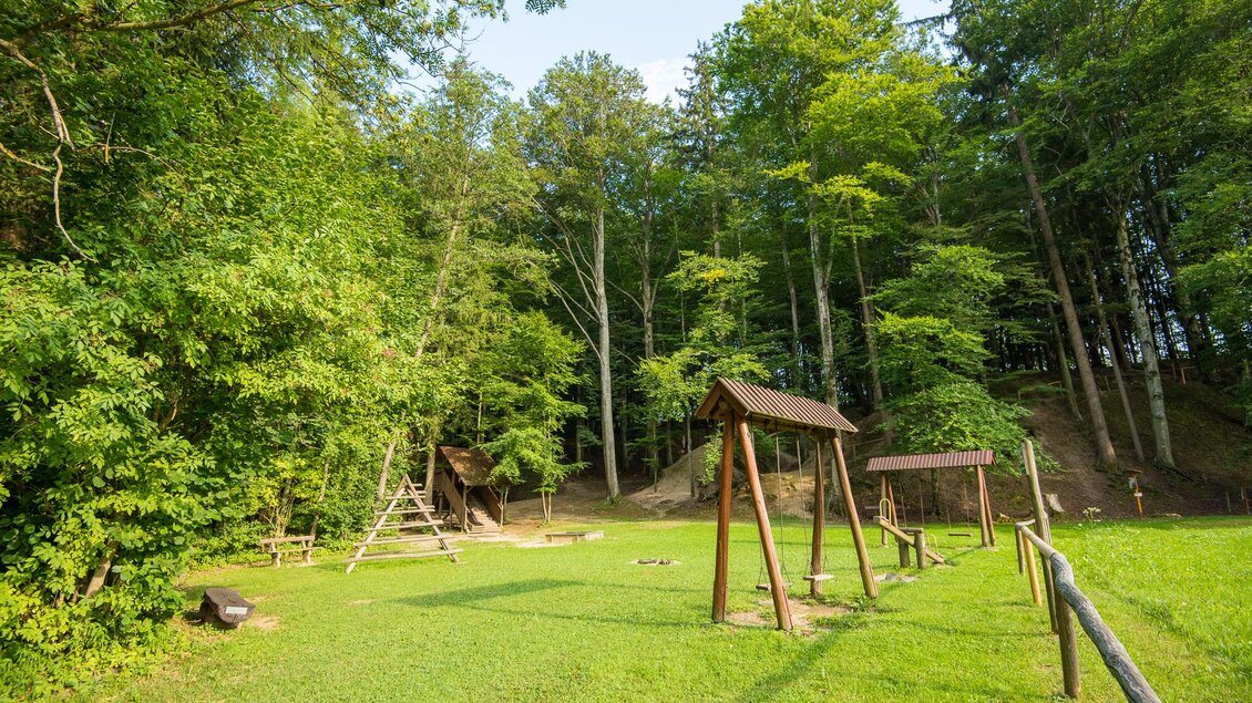 Ein ruhiger Spielplatz im Grünen mit Schaukeln und viel umgebender Natur. Hohe Bäume bieten Schatten und eine entspannte Atmosphäre. | © Helmut Schweighofer