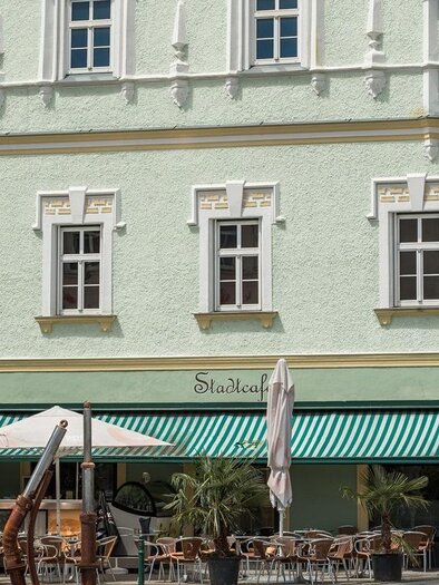 Fassade des Stadtcafés Voitsberg mit Gastgarten, Markisen und Sitzplätzen vor dem Gebäude. | © Dieter Sajovic